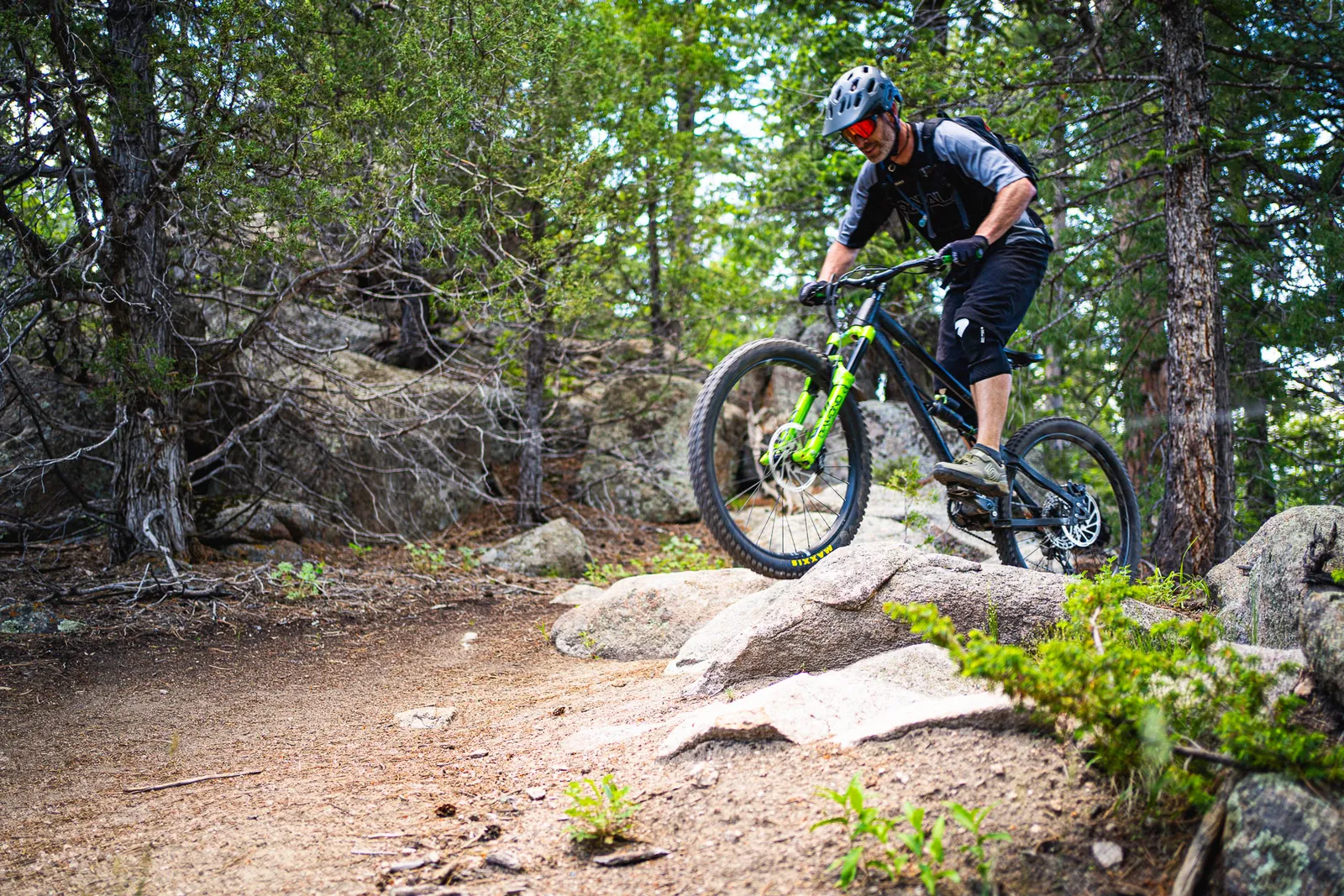 A mountain biker riding through a rocky forest section